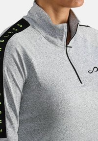 Grijs half-zip pullover gemaakt van textuurstof, voorzien van zwarte schouderpanels met "ENDLESS" in neon geel en een klein logo op de borst.