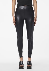 Svarta högmidjade leggings gjorda av ett glansigt, stretchy material. Tight passform med en slät textur och ankel-lång design.