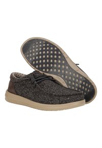 Scarpe di tessuto grigio e nero con un tacco in pelle marrone liscia, suola beige, lacci neri e un rivestimento interno decorato.