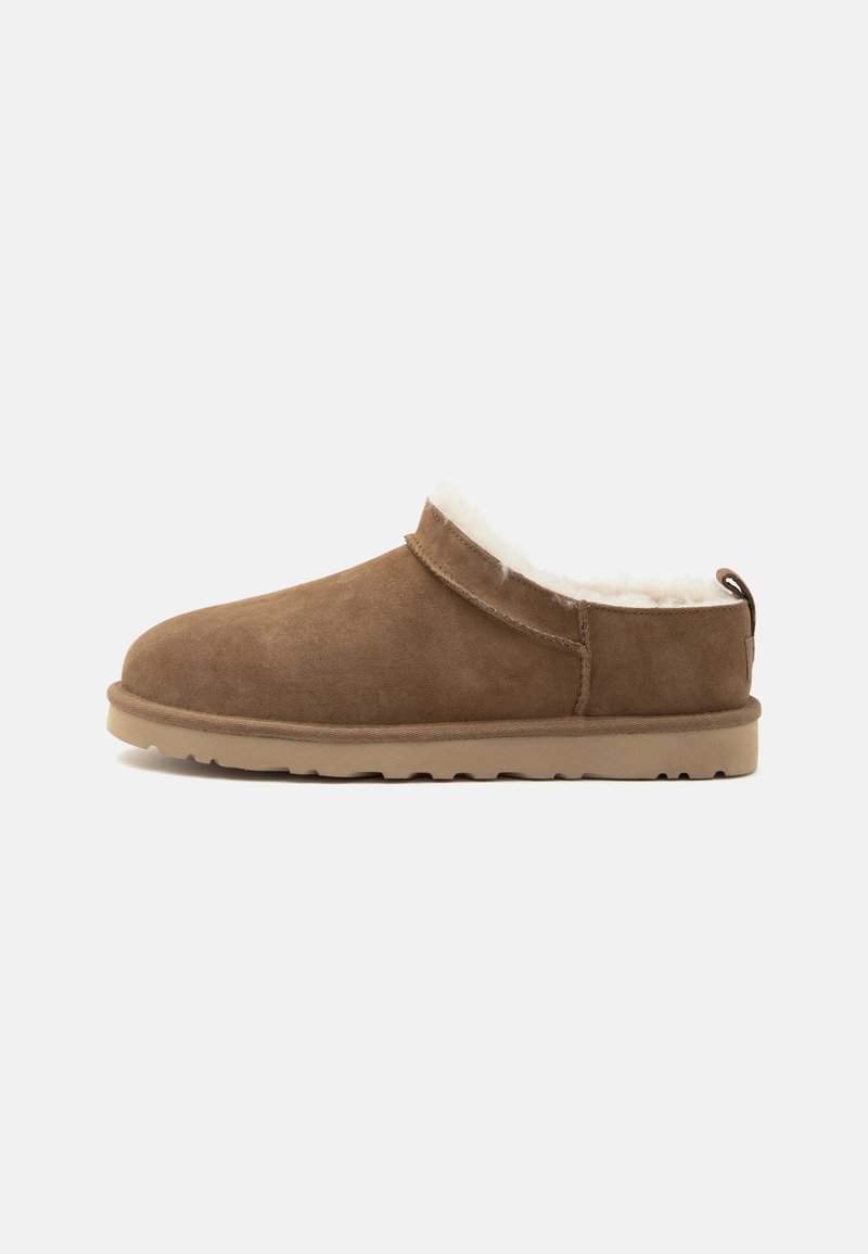 Chausson marron en daim à enfiler avec semelle beige et doublure polaire blanche, conçu pour la chaleur et le confort à l’intérieur.