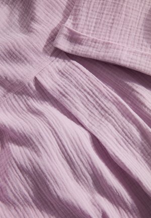 Lichtroze textiel met een gekreukt patroon, met zachte plooien en een schuine rand, die een casual en lichtgewicht ontwerp laat zien.