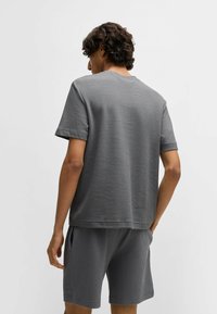 Grå texturerad kortärmad tröja med rund halsringning, designad med ett våffelmönster och matchande shorts.