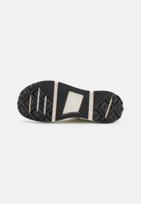 Semelle extérieure en caoutchouc noir avec un motif de bande de roulement texturé, dotée d'une semelle intermédiaire blanche et d'un accent rectangulaire au centre pour la stabilité.