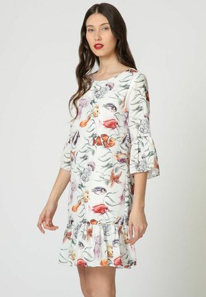 Vestido blanco con motivos de peces coloridos y acuáticos, mangas cortas con volantes y un bajo acampanado con volantes, hecho de tela ligera.