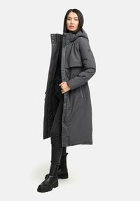 Lang grå parka med hætte, frontlynlås, trykknapper og sidelommer. Lavet af vandafvisende materiale, der har en let skinnende tekstur.