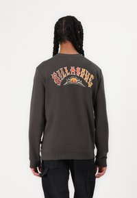 Gray sweatshirt with a ribbed crewneck and cuffs. Large colorful "BILLABONG" graphic on the back with a stylized design.