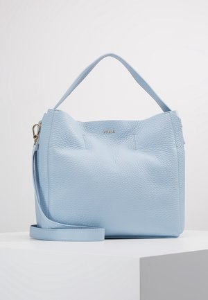 Sac à main en cuir texturé bleu clair avec une poignée courte et une bandoulière amovible, présenté sur un socle blanc.