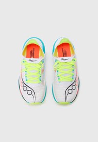 Zapatillas de correr blancas con parte superior texturizada, cordones de neón amarillos, acentos turquesa y detalle de diseño negro en el costado. Plantilla interior de color naranja brillante visible.