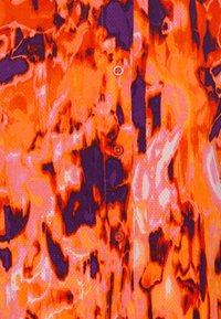 Chemise à manches courtes dans un imprimé abstrait vibrant d'orange, de violet et de rose. Présente une texture uniforme et des boutons sur le devant.