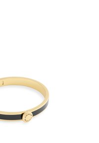 Bracelet en métal doré avec un émail noir en insert et un charm circulaire de marque. Texture lisse ; design rond et élégant.