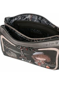 Clutch sintético negro con acentos metálicos y diseños bordados, incluyendo la Torre Eiffel y arte de personajes, con dos compartimentos con cremallera.
