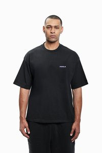 Sort bomulds oversized t-shirt med korte ærmer og rund halsudskæring. Den har et lille, lilla "FAVELA"-logo på brystet.