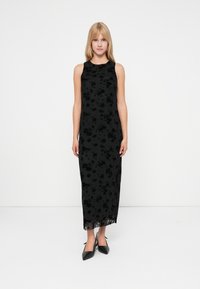 Zwarte bloemen midi-jurk met een hoge halslijn, mouwloos ontwerp en doorschijnende overlay. Bevat een aansluitend lijfje en een vloeiende rok.