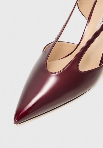 Burgundy lackskor med hög klack, spetsig tå och utskuren sidodesign. De har en slät, glänsande yta och svart sula.