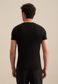 T-shirt noir à manches courtes en tissu lisse, à design ajusté, avec un col rond et des coutures minimalistes, vu de dos.