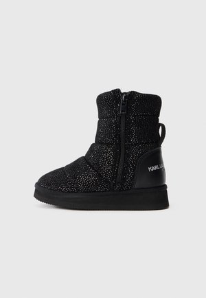 Bota de inverno preta até ao meio da panturrilha com textura salpicada em prata, fecho lateral, laço para puxar e sola plana, com a marca "Karl Lagerfeld" no calcanhar.