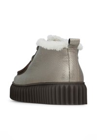 Metaliczne szare botki za kostkę z teksturowaną skórzaną cholewką i miękkim białym futerkiem. Posiadają grubą, żłobioną gumową podeszwę zapewniającą przyczepność.