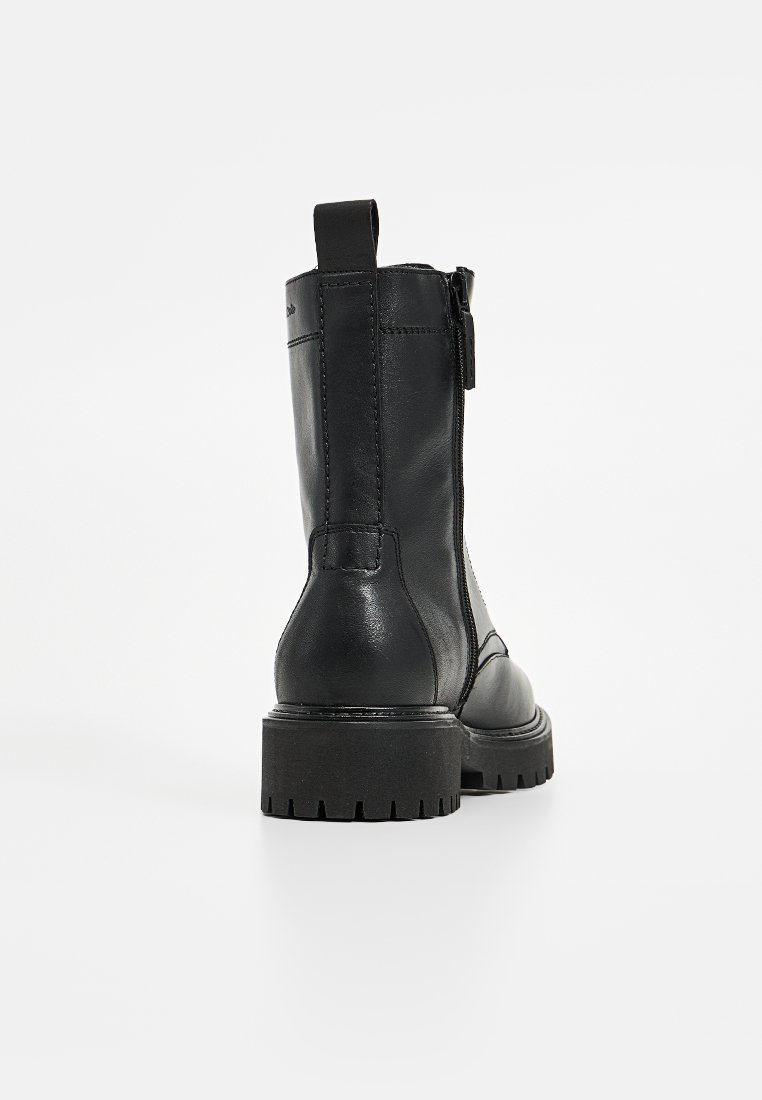 Schwarze Lederstiefeletten mit einer groben Sohle, seitlichem Reißverschluss und Ziehlasche. Das Design zeichnet sich durch verstärkte Nähte und eine glatte Oberfläche aus.