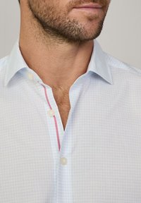 Himmelblau karierter Hemd mit Button-Down-Kragen, versehen mit einem kontrastierenden pinken Akzent entlang der Knopfleiste und weißen Knöpfen.