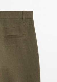 Pantalon vert olive en tissu texturé, avec une ceinture lisse, des passants pour ceinture et une seule poche arrière.