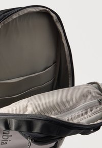 Ανοιχτό σακίδιο πλάτης που δείχνει την εσωτερική επένδυση για φορητό υπολογιστή με επένδυση από μαξιλάρι και δίχτυ με φερμουάρ, με εσωτερική επένδυση ανοιχτό γκρι.