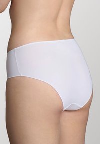 Slip bianchi a vita alta con una finitura liscia e opaca. Il tessuto è elasticizzato e il design presenta una vita senza cuciture e bordi arrotondati.