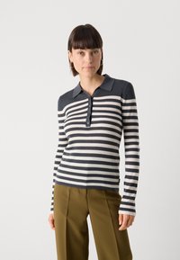 Polo à manches longues rayé en tissu côtelé bleu marine et crème avec un col et une patte de boutonnage à cinq boutons. Présente des manches fines.