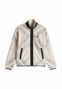 Giacca in pile di colore crema con motivi paisley neri, chiusura con zip completa, dettagli neri e colletto alto. Presenta tasche laterali.