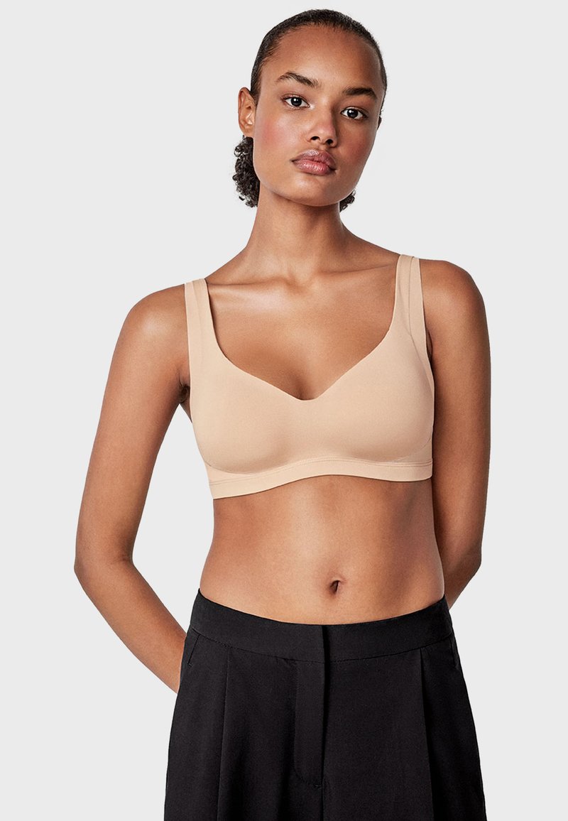 Sujeta-beige inalámbrico con tirantes anchos y un diseño liso y sin costuras. Tejido suave con un acabado mate y sin costuras visibles.