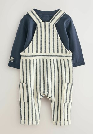Gestreept overall set met een marineblauw langemouwshirt en crèmekleurige stof met donkere strepen. Inclusief zakken aan de zijkanten en opgerolde zomen.