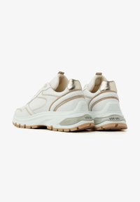 White sneakers featuring a cushioned sole, metallic gold accents, and textured detailing on the sides.