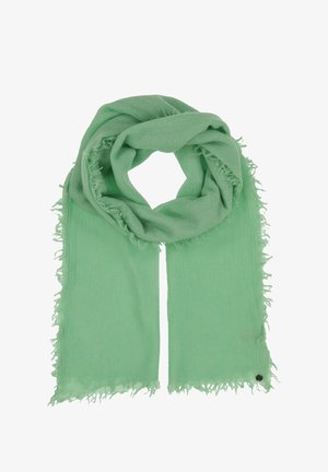 Foulard vert clair avec des bords effilochés, fabriqué en tissu doux. Il a une forme rectangulaire simple et un petit emblème sombre attaché.