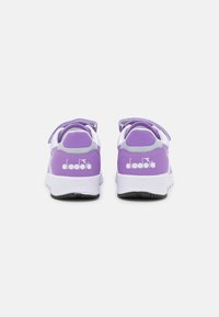 Sneakers viola e bianche con una parte superiore in sintetico liscio, fascia con chiusura a velcro, collo imbottito e suola in gomma testurizzata. Logo sul tallone.