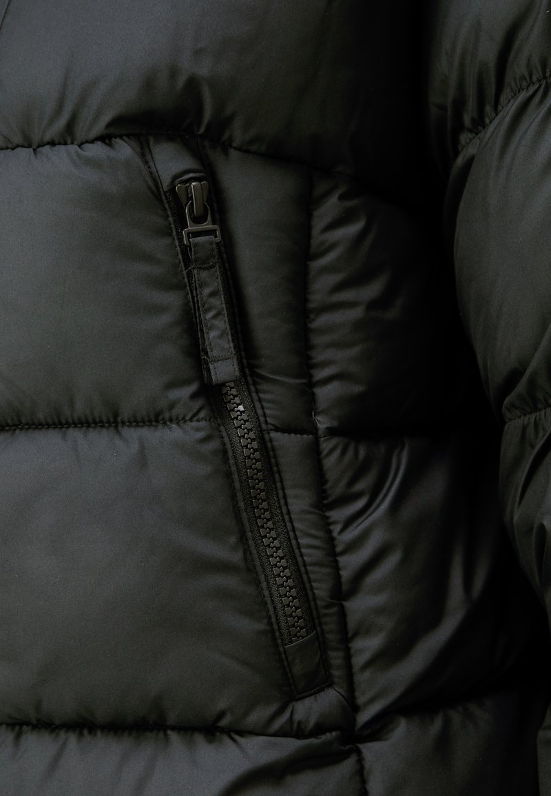 Czarna kurtka puffer z widoczną kieszenią na zamek, pikowanym wzorem i gładkim wykończeniem. Materiał jest lekki i ocieplony.