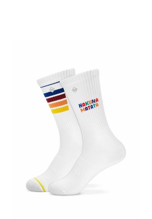 Chaussettes blanches montantes avec des bord-côtes, l'une avec des rayures colorées et l'autre avec "HAKUNA MATATA" en lettres multicolores.