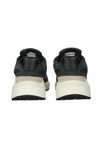 Sneakers neri con parte superiore in pelle scamosciata testurizzata e pelle liscia. Dotati di una zeppa beige, suola in gomma e dettagli neri.