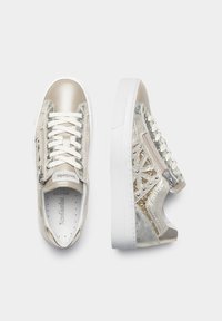 Metallic sølv sneakers med hvide såler, der har præget detaljer og dekorative nitter. Snørebånd og en lynlåsdetaillering på siden øger funktionaliteten.