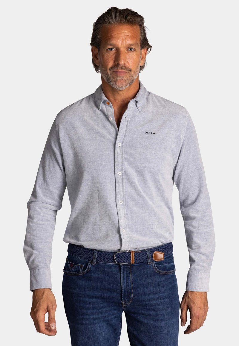 Lichtgrijs overhemd met lange mouwen, van een gestructureerde stof, met kraag en geborduurd logo op de borst, gecombineerd met donkere denim jeans en een geweven riem.