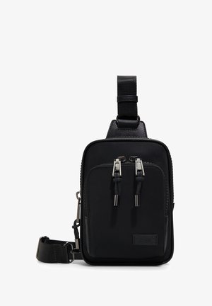 Zwarte schoudertas van duurzaam fabric met een gladde textuur. Voorzien van twee ritszakken, een verstelbare schouderband en hardware in zilverkleur.