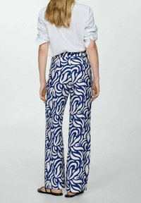 Pantalon à jambes larges avec un motif abstrait bleu et blanc, en tissu léger. Comprend une taille haute et une coupe évasée.