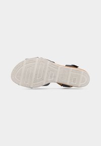 Μαύρο σανδάλι με λουράκια και υφή σε σόλα από καουτσούκ, διαθέτει ανάγλυφο λογότυπο και ρυθμιζόμενες αγκράφες για ασφαλή εφαρμογή.