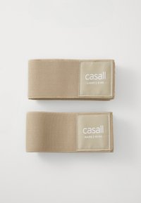 Dva bež otpora trake, označene "casall", jedna označena "LAGANO | 3 KG" a druga "TEŠKO | 10 KG", s teksturiranom tkaninom površinom.