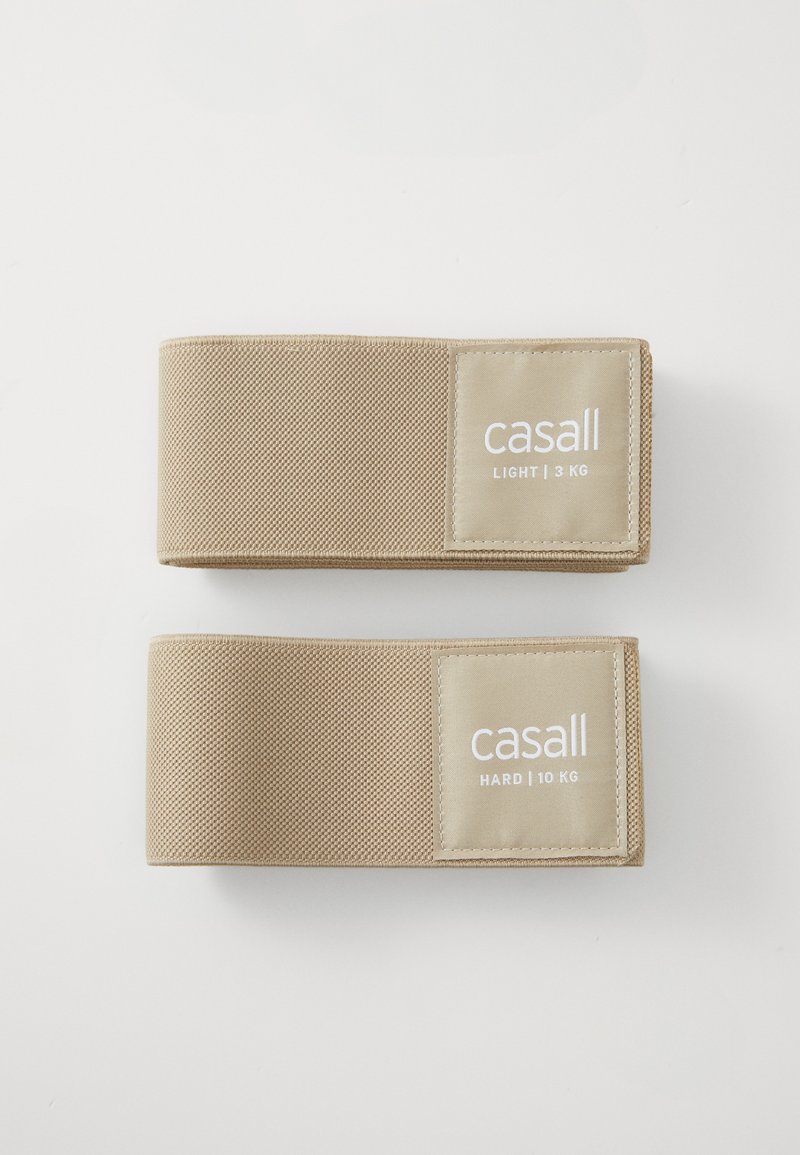 Dva bež otpora trake, označene "casall", jedna označena "LAGANO | 3 KG" a druga "TEŠKO | 10 KG", s teksturiranom tkaninom površinom.