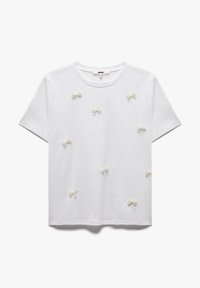 Camiseta de algodón blanca con múltiples pequeños lazos texturizados en un color crema claro, escote redondo y mangas cortas.