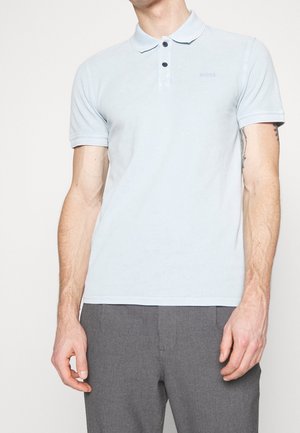 Lysblå kortærmet polo skjorte med krave, to knaplukninger og prægede logo på brystet. Lavet af blødt stof.
