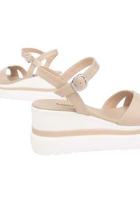 Sandali platform beige con una superficie sintetica lucida, cinturino alla caviglia regolabile e suola in gomma bianca con una striscia color beige chiaro.