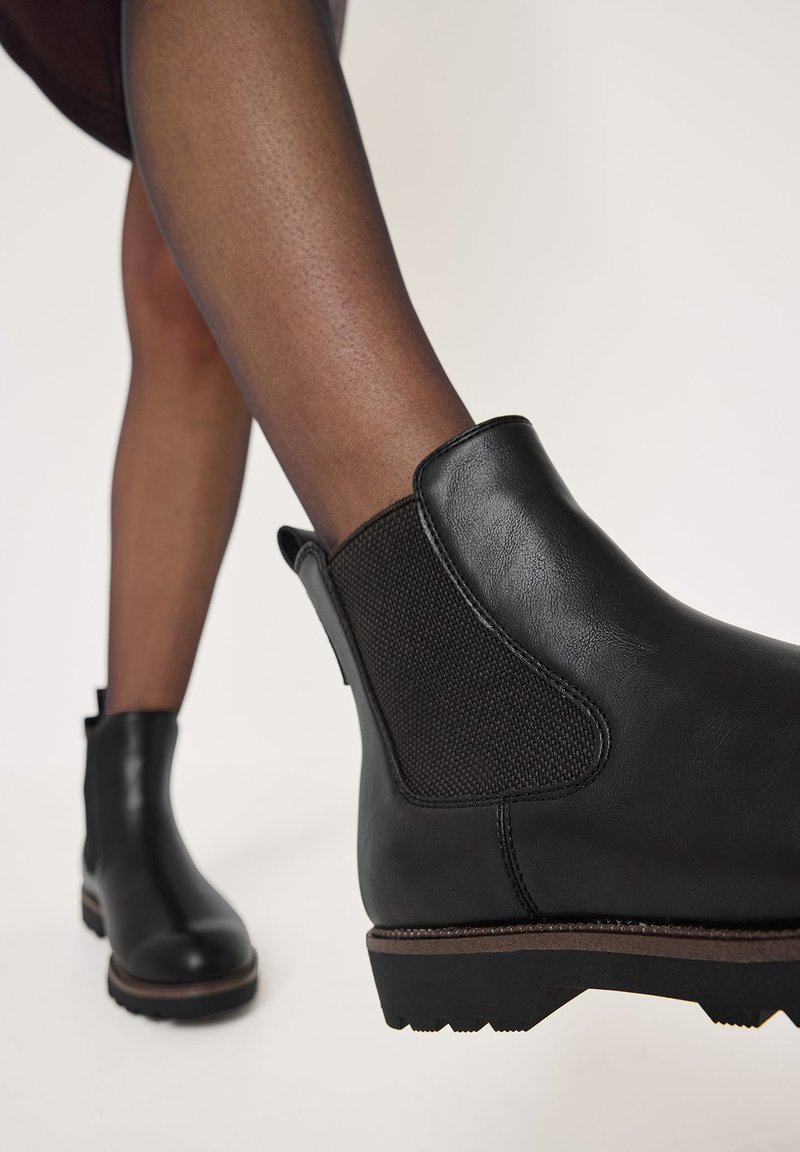 Stivali alla caviglia neri con esterno in pelle liscia e pannelli elastici laterali. Suola in gomma robusta con battistrada testurizzato per una migliore aderenza.