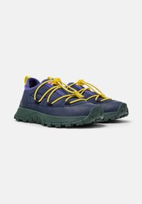 Chaussures de plein air bleu marine avec des lacets élastiques jaunes, tige texturée, semelle crantée verte et col rembourré pour un confort optimal.