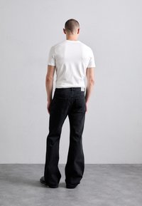 EYTYS CYRUS RAVEN - Flared Jeans - black