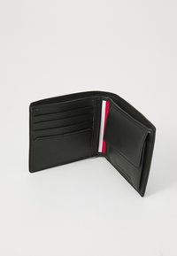 Zwarte leren portemonnee geopend om verschillende kaartsleuven te tonen en een rood, wit en blauw gestreept accent aan de binnenkant. Zachte textuur.